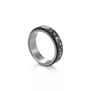 Close-up of black spinner ring with engraved silver moon and stars on stainless steel