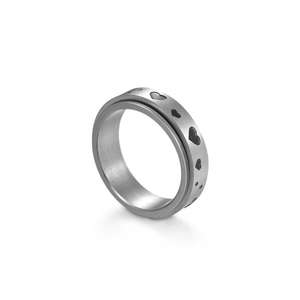 Macro detail of rotating fidget ring with hollow heart patterns and brushed metal finish