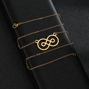 Collier doré style baroque avec pendentif infini sur une boîte à bijoux noire