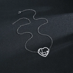 Silver love heart stethoscope pendant necklace made of stainless steel on black display