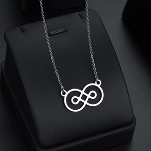 Collier infini géométrique à perles baroques argenté sur support de présentation
