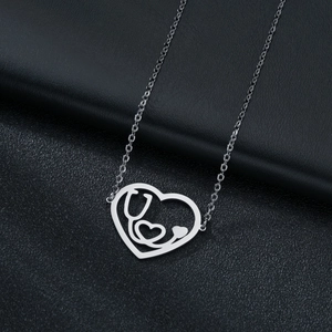 Silver stethoscope heart pendant necklace with thin chain on a dark leather background