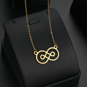 Collier élégant en titane doré avec perle baroque et pendentif à nœud géométrique