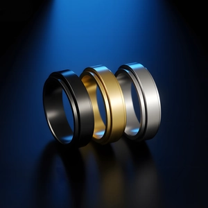 Trio of polished gold, black, and silver spinner rings for men in stainless steel