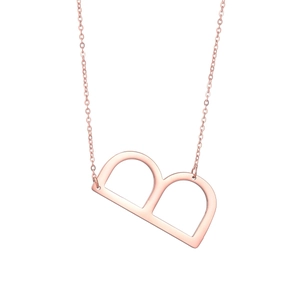 Gros plan détaillé du collier avec pendentif lettre B en or rose et chaîne fine polie