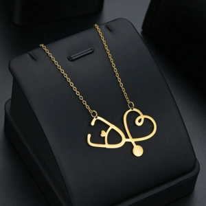 Élégant collier pendentif cœur stéthoscope doré sur un support à bijoux en cuir noir