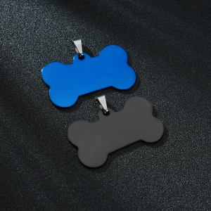 Close-up of bone-shaped stainless steel pet ID tags in matte black and vibrant blue finishes