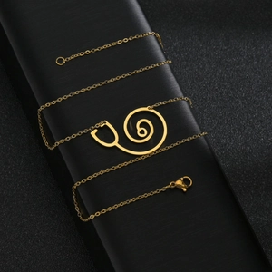 Collier stéthoscope cœur doré pour femme sur boîte à bijoux noire texturée de luxe