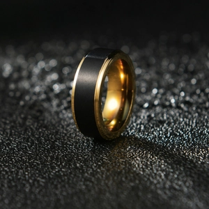 Two-tone black brushed and gold polished stainless steel ring for men on dark sand