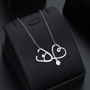 Collier avec pendentif stéthoscope coeur en acier inoxydable sur support à bijoux