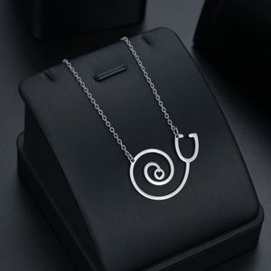 Collier stéthoscope argenté avec pendentif cœur sur présentoir en cuir noir de luxe