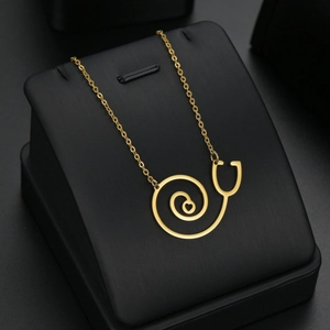 Collier doré avec pendentif cœur stéthoscope sur boîte à bijoux en cuir noir