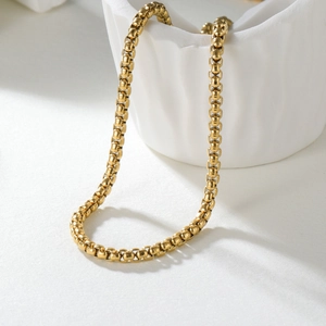 Elegant 2mm golden stainless steel box chain necklace displayed on white ceramic base