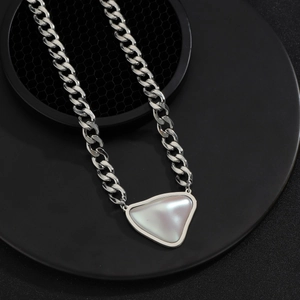 Grosse chaîne cubaine argentée avec pendentif cœur irisé sur présentoir noir moderne