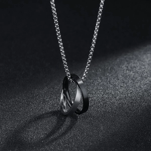 Macro view of interlocking silver and matte black Mobius rings on a sleek box chain