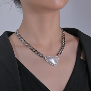 Grosse chaîne en argent avec pendentif triangulaire en nacre porté par un mannequin