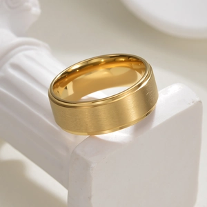 Détail d'une bague en titane doré 8mm avec finition brossée mate sur une colonne en pierre