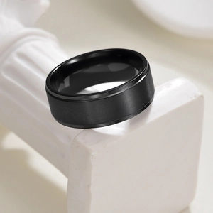 Détail macro d'une bague homme de 8 mm en titane noir avec finition mate brossée et bords polis