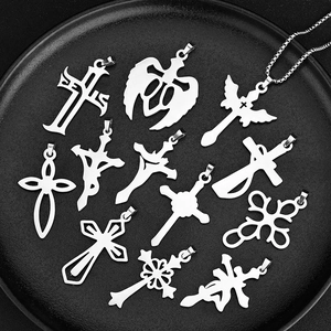 Collection of various stainless steel cross pendants displayed on a black textured tray