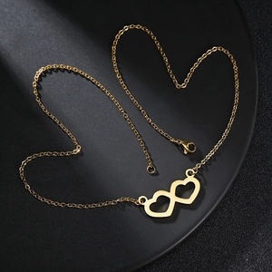 Minimalist double heart gold necklace displayed on a black tray for a premium visual look