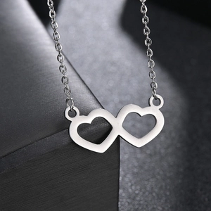 Minimalist interlocking double heart pendant necklace in silver finish with a sleek cross chain