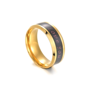 Gros plan d'une bague en acier doré avec bande noire et inscription violette I Love You