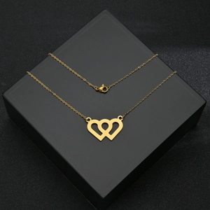 Collana con ciondolo a doppio cuore in oro lucido su una scatola regalo nera testurizzata