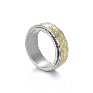 Detail of the rotating titanium steel ring with gold Celtic dragon pattern and inner band