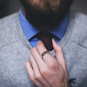 Détail d'une bague homme en acier avec incrustation bois et turquoise sur la main