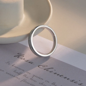 Macro detail of silver titanium ring with shimmering ice foil inlay and polished edges