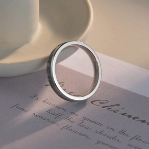 Close-up of a 4mm silver titanium steel ring with shell inlay on a poetic paper card