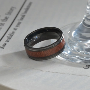 Men's black stainless steel ring featuring a natural red wood inlay and stepped edges
