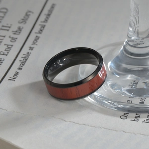 8mm black titanium steel ring for men featuring red wood inlay on a vintage paper background