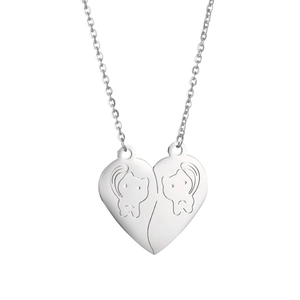 Close-up of split heart pendant necklace with minimalist cat engravings in stainless steel