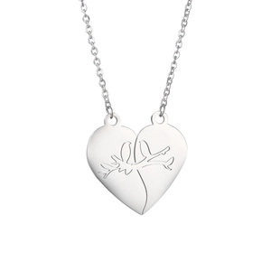 Detailed view of silver heart-shaped puzzle pendant with engraved birds on steel chain