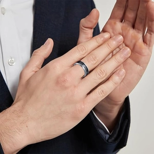 Men's 8mm stainless steel ring with black fishbone pattern on male model wearing suit