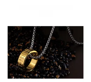 Detail of Viking Rune pendant in gold finish with silver box chain on black stones