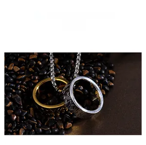 Macro shot of gold and silver Viking rune rings on a pearl chain over dark stones