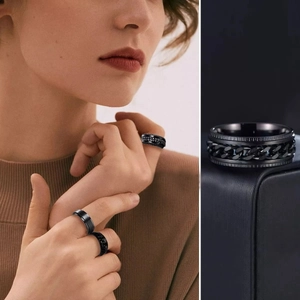 Detail of black stainless steel spinner ring with rotatable cuban chain inlay on a box