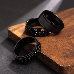 Black stainless steel spinner ring set with chain and Roman numerals on wooden stand