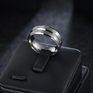 Macro shot of silver stainless steel ring with brushed texture and polished groove detail