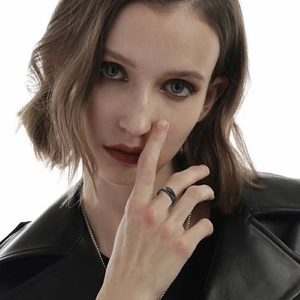 Close-up of black snake-shaped ring with textured scales worn by a model in leather jacket
