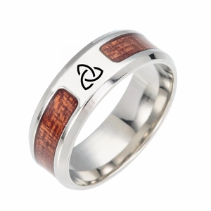 Dettaglio macro di anello in acciaio argento con intarsio in legno e nodi celtici neri