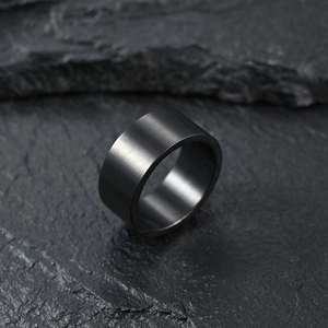 Détail macro d'une bague rotative large en titane gris foncé avec finition brossée mate