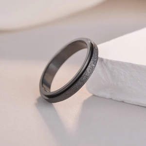 Macro detail of 4mm gunmetal titanium steel spinner ring with frosted sandblast finish