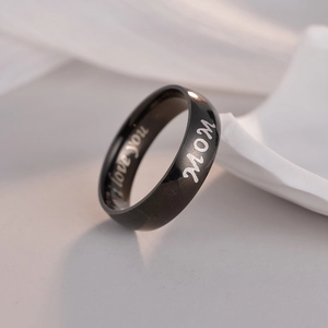 Makroaufnahme von schwarzem Ring mit MOM und I love you Laser-Gravuren