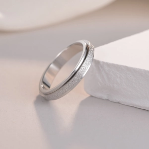 Polished silver stainless steel spinner ring with a matte sandblasted finish on stone