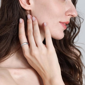Detailed view of 6mm silver titanium ring with small diamond on female model finger
