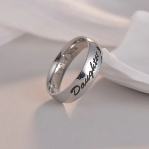 Makro-Detail des Silberrings mit Daughter und I Love You Gravuren in Geschenkumgebung
