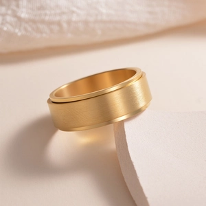 8mm matte golden rotatable titanium steel ring for men on white stone background